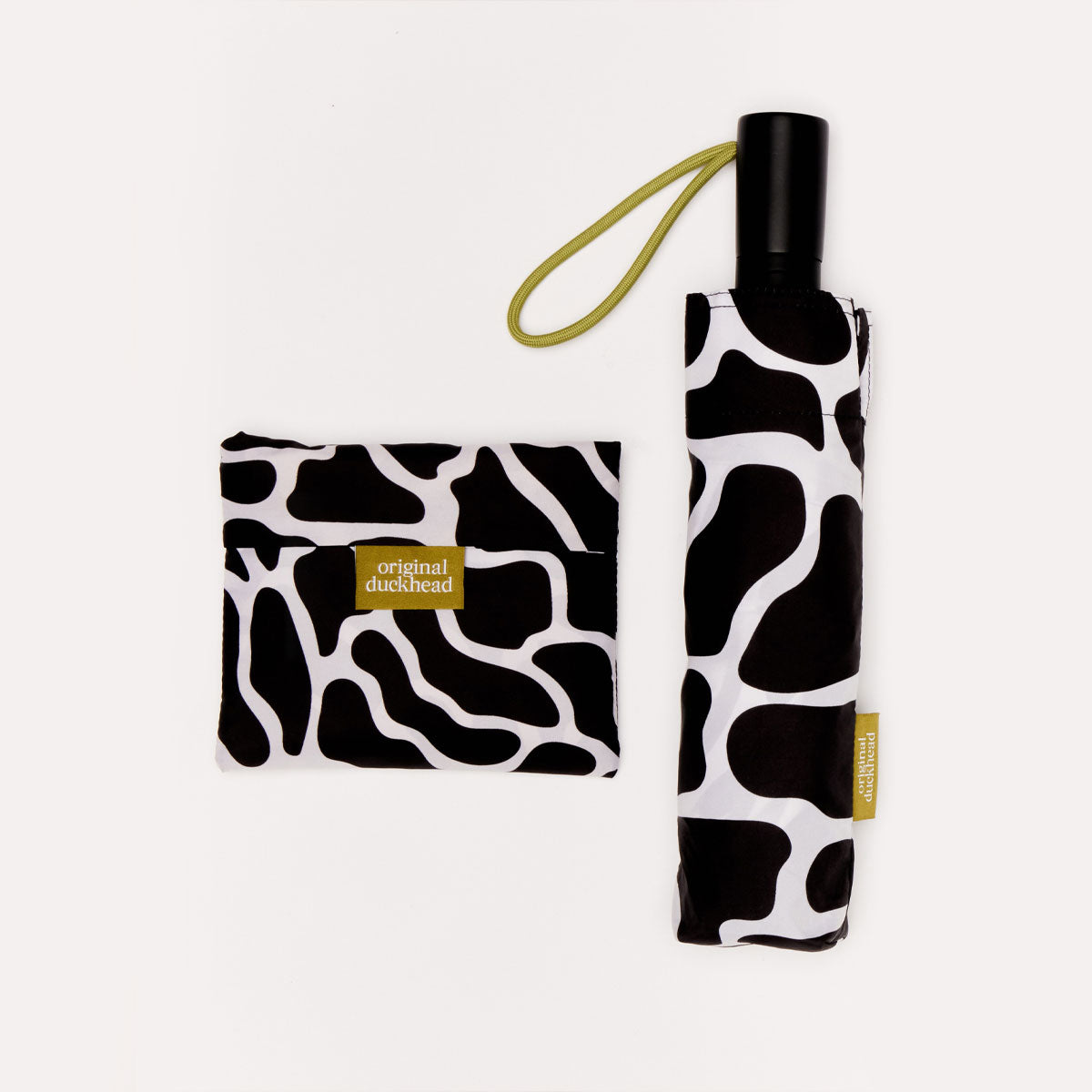 Black and white patterned umbrella and matching pouch with 'original duckhead' label on a light gray background