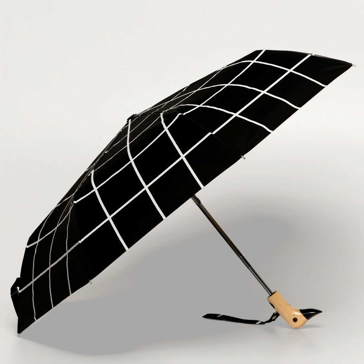 Black umbrella with white grid pattern on a light background