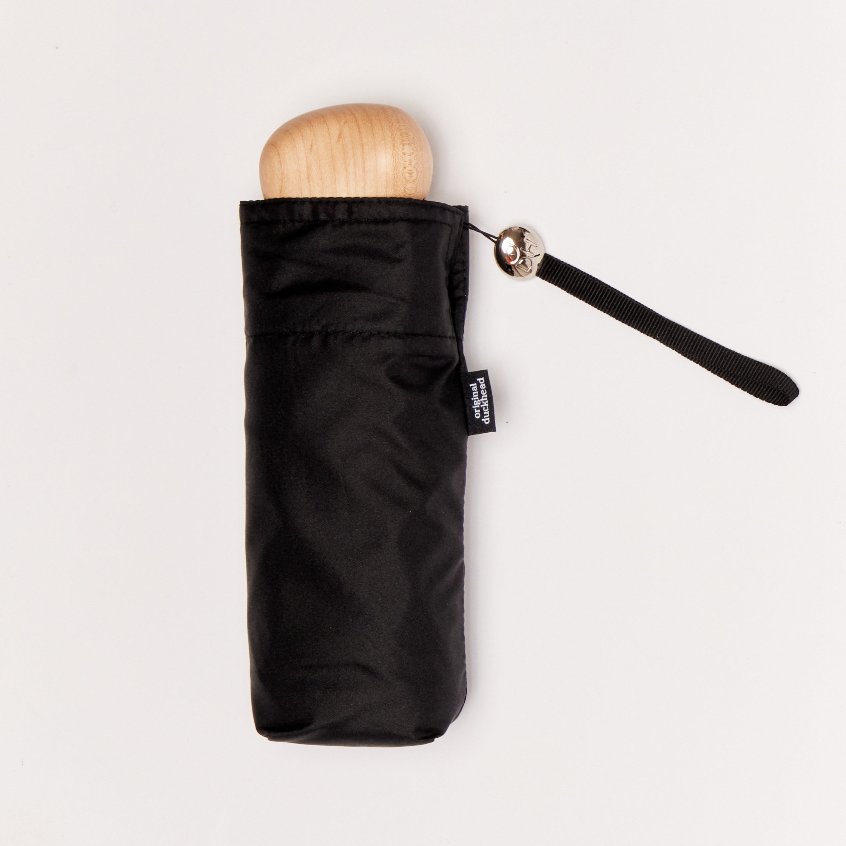 Black mini umbrella with wooden handle on a light background