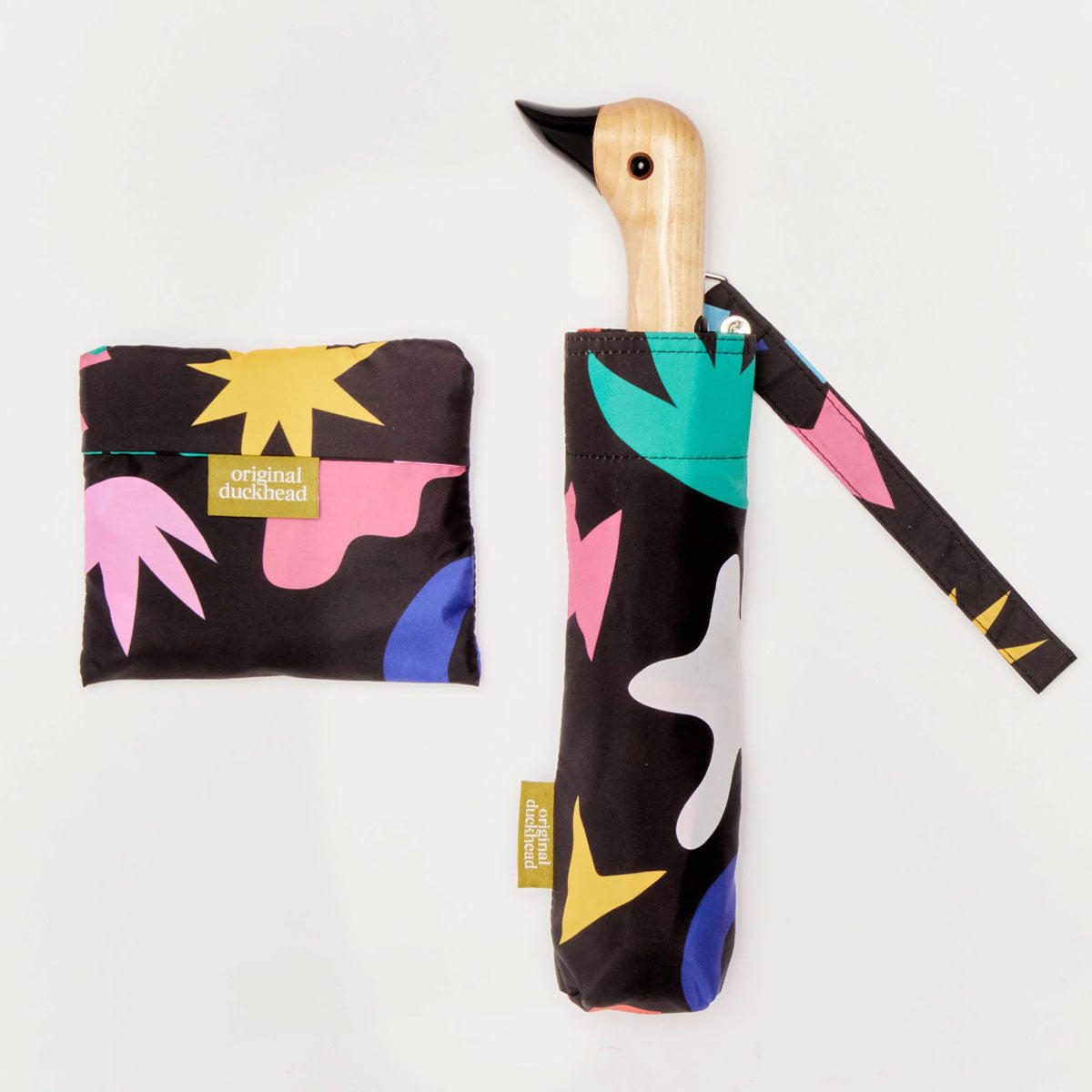 Colorful umbrella with abstract patterns and a matching pouch on a white background