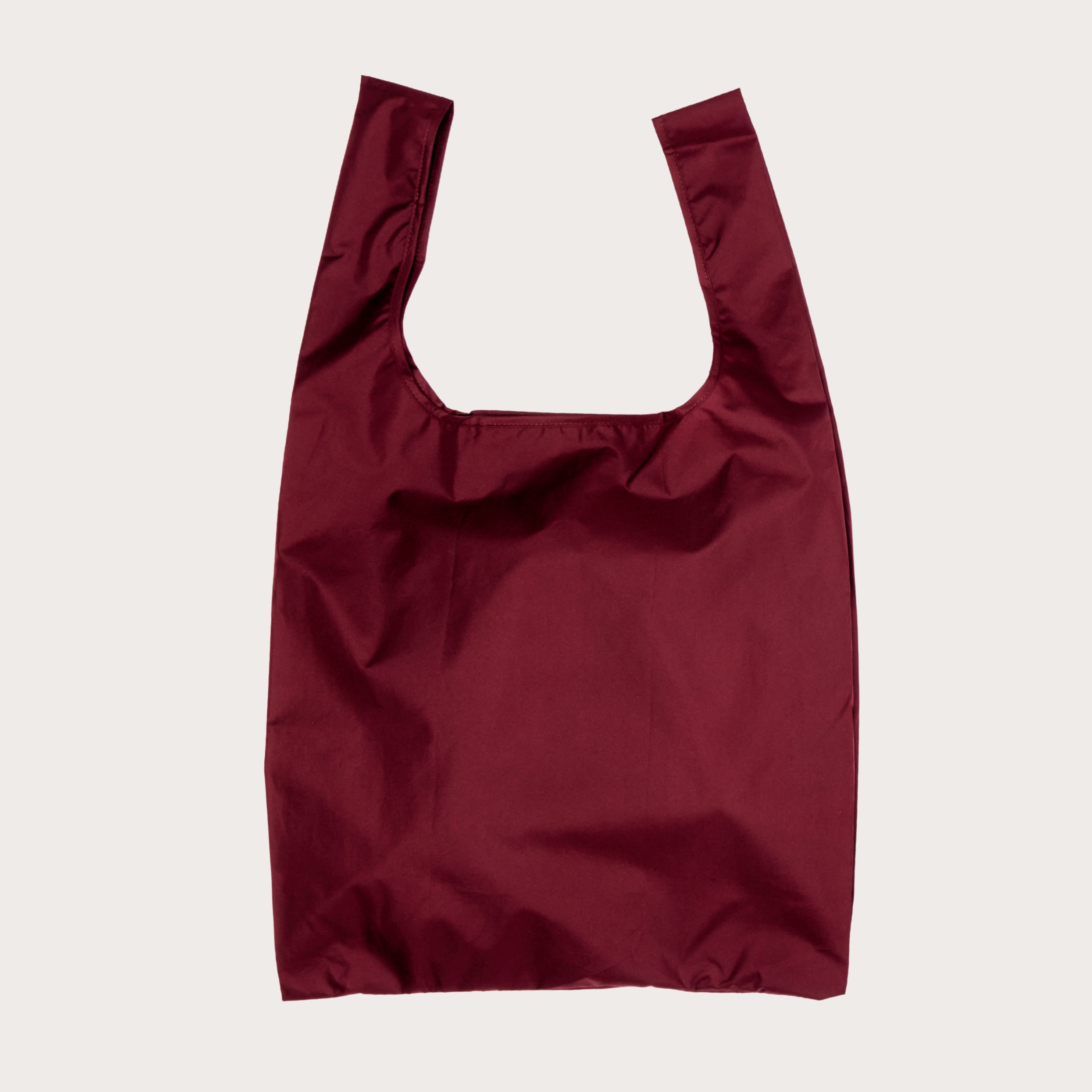 Cherry red reusable shopping bag on a light plain background