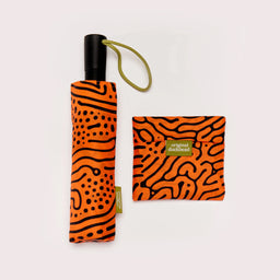 Foldable umbrella with orange and black pattern and matching pouch on a white background